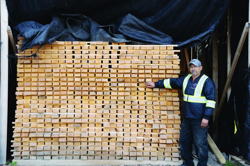 Pat Bayer with some of the lumber produced at a Norway House sawmill. Photo by Roman Swanson_NOMVD Media.