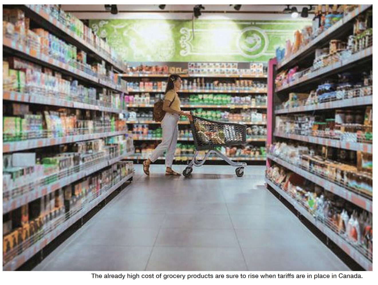Woman wearing backpack pushes shopping cart through grocery store