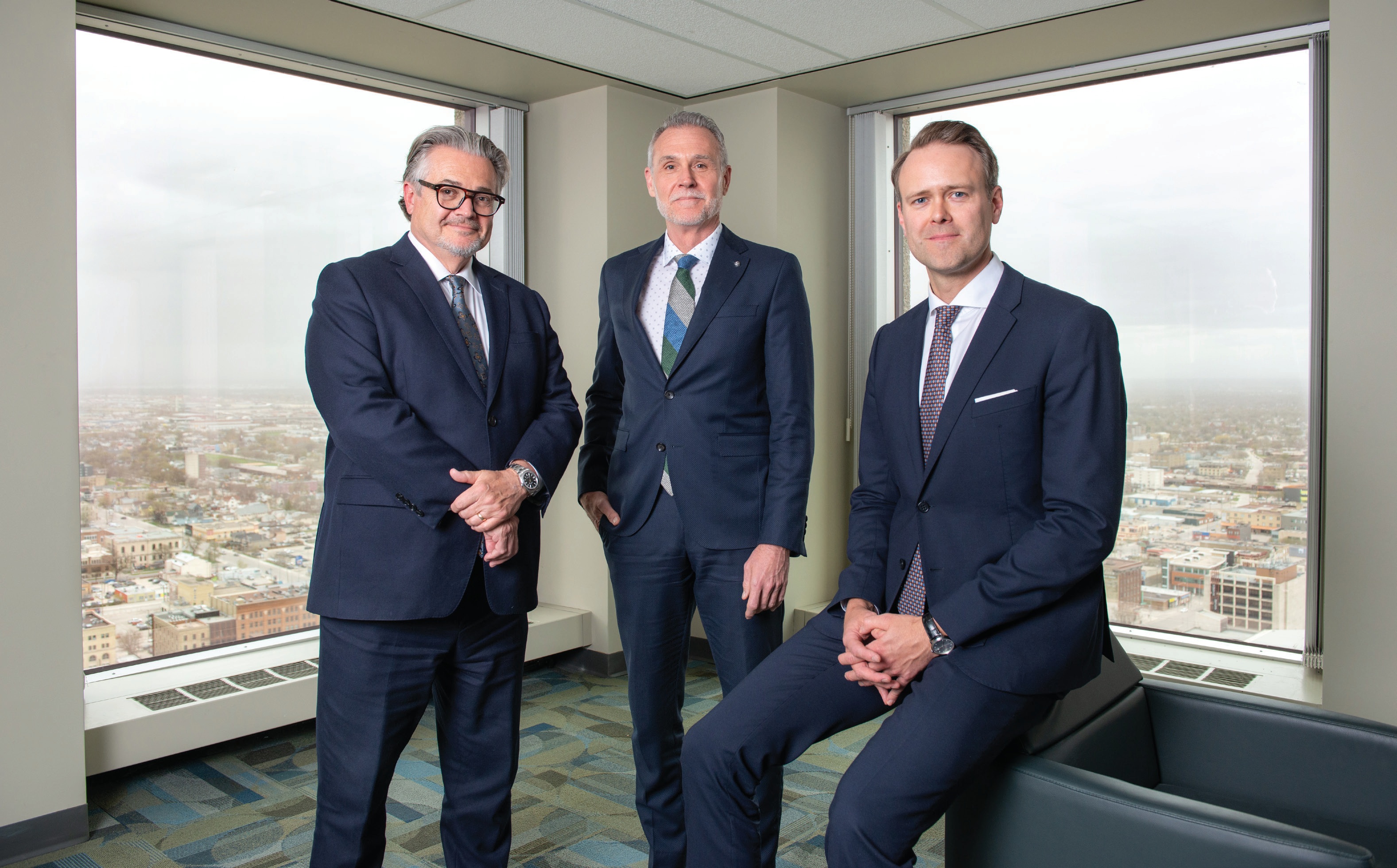 Stuart Blake, Jody Langhan and Thor Richardson beside the windows of the Richardson Building.