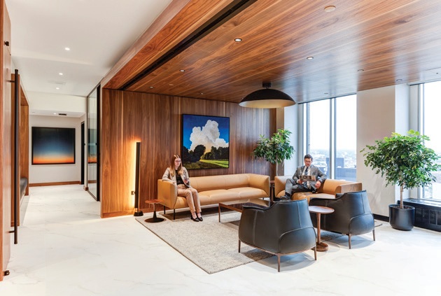 A lounge with seating, wood finishes and city views.