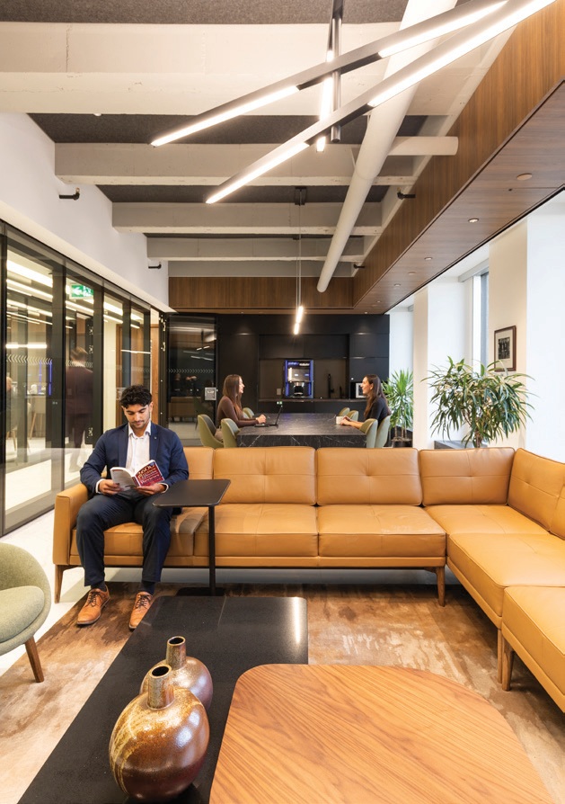 A seating area with sofas, coffee tables and overhead lighting.